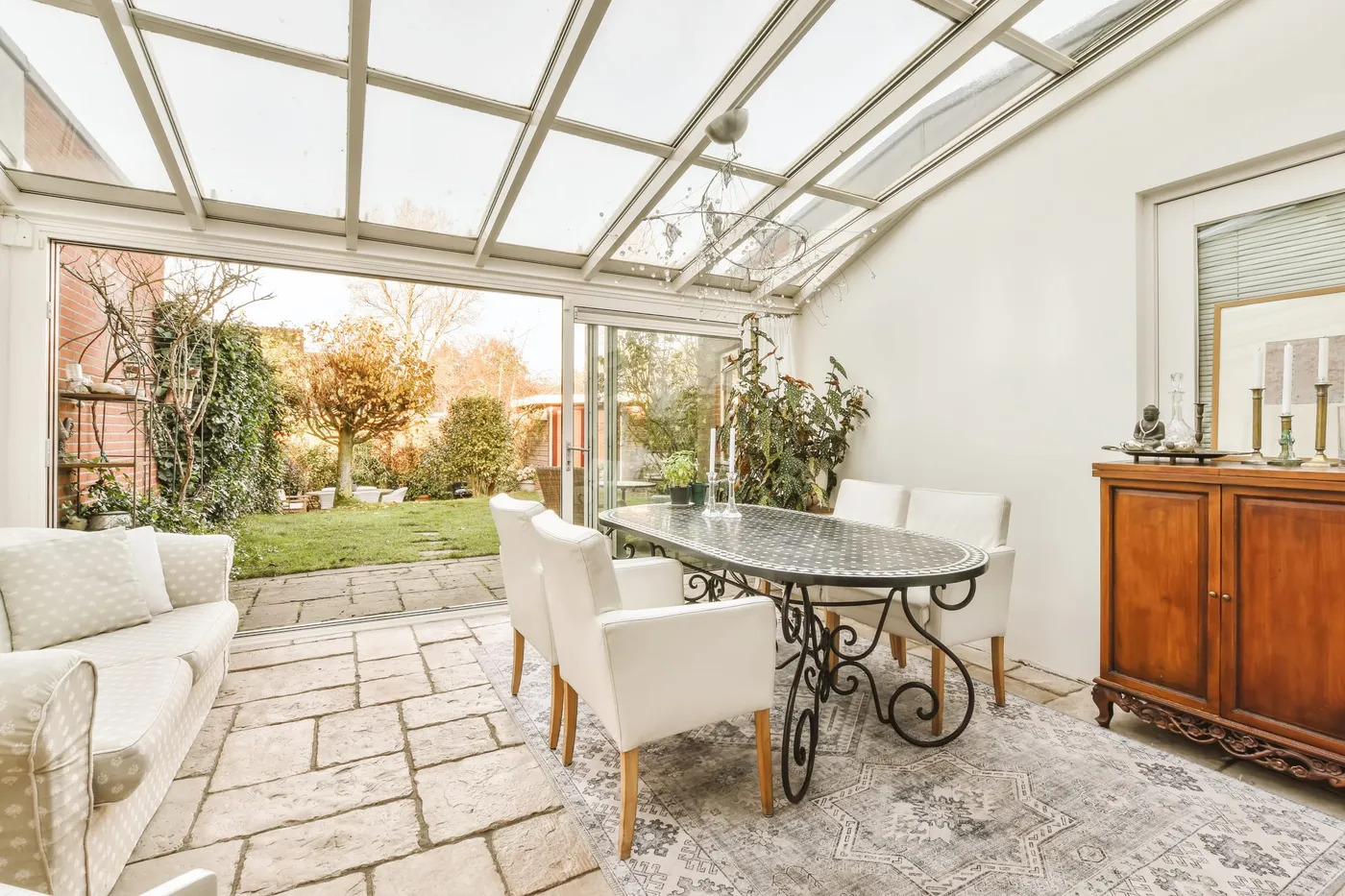 Intérieur lumineux d'une véranda, vue sur le jardin